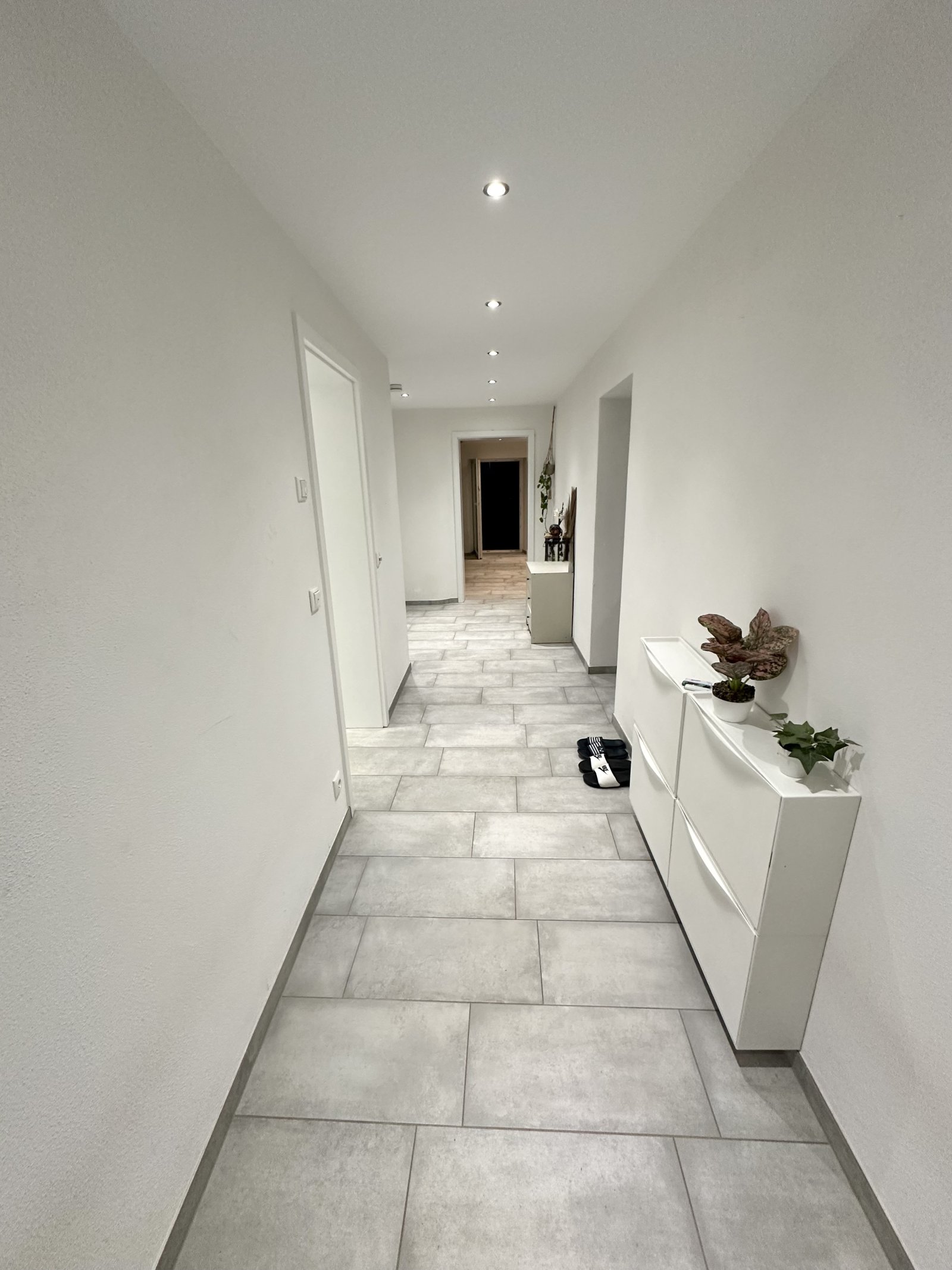 Lichtdurchfluteter Flur mit eleganter Natursteinoptik