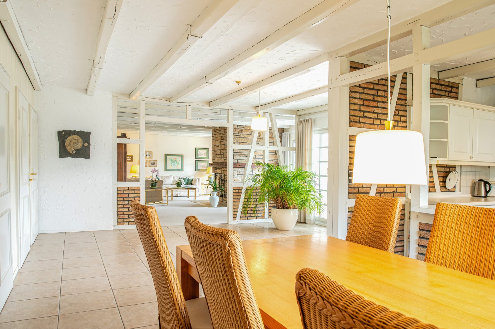 Loft-Charme: Offene Wohnküche mit Backsteinwänden und eleganten Sichtbalken Loft-Charme: Offene Wohnküche mit Backsteinwänden und eleganten Sichtbalken