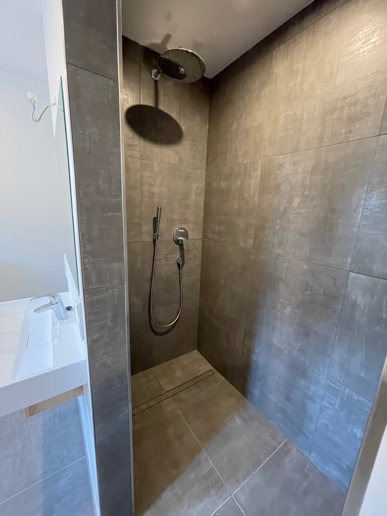 Wellness-Oase: Edle Regendusche mit geräumiger Duschnische und edlem Betonlook-Ambiente Wellness-Oase: Edle Regendusche mit geräumiger Duschnische und edlem Betonlook-Ambiente