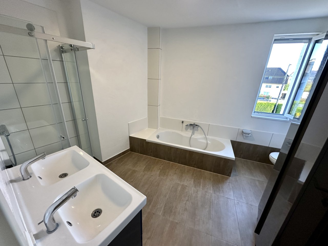 Großzügige Dusche und Wanne in harmonischer Raumgestaltung