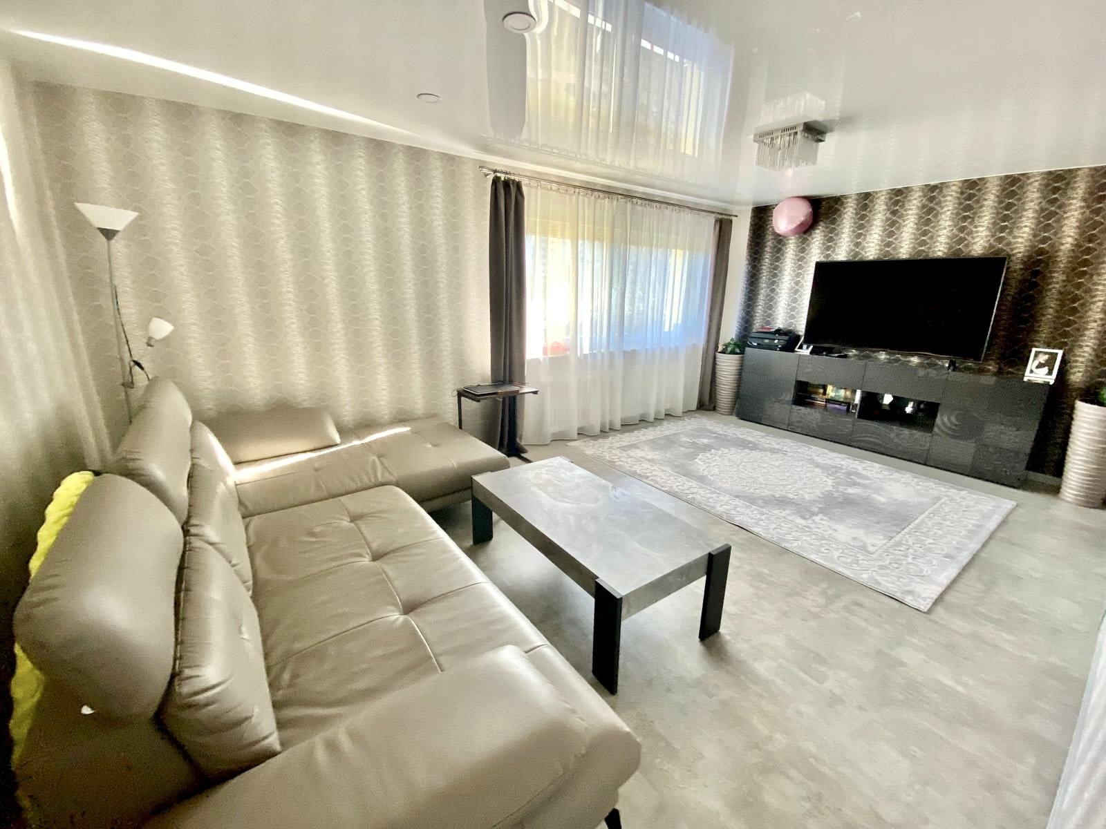 Lichtdurchflutetes Wohnzimmer mit moderner TV-Wand 