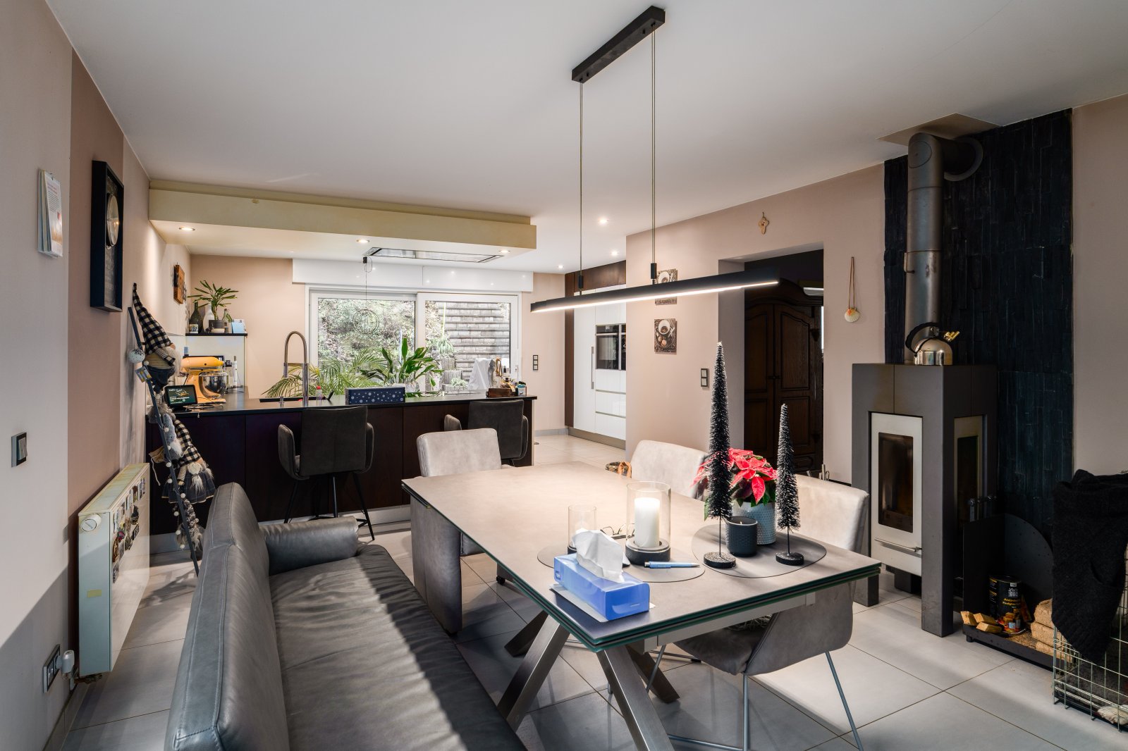 Wohn-Essküche mit elegantem Kaminofen und modernem Raumdesign