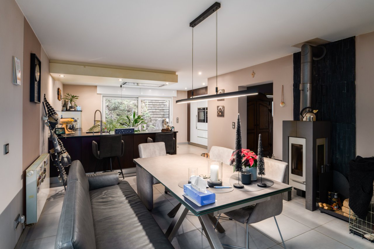 Wohn-Essküche mit elegantem Kaminofen und modernem Raumdesign