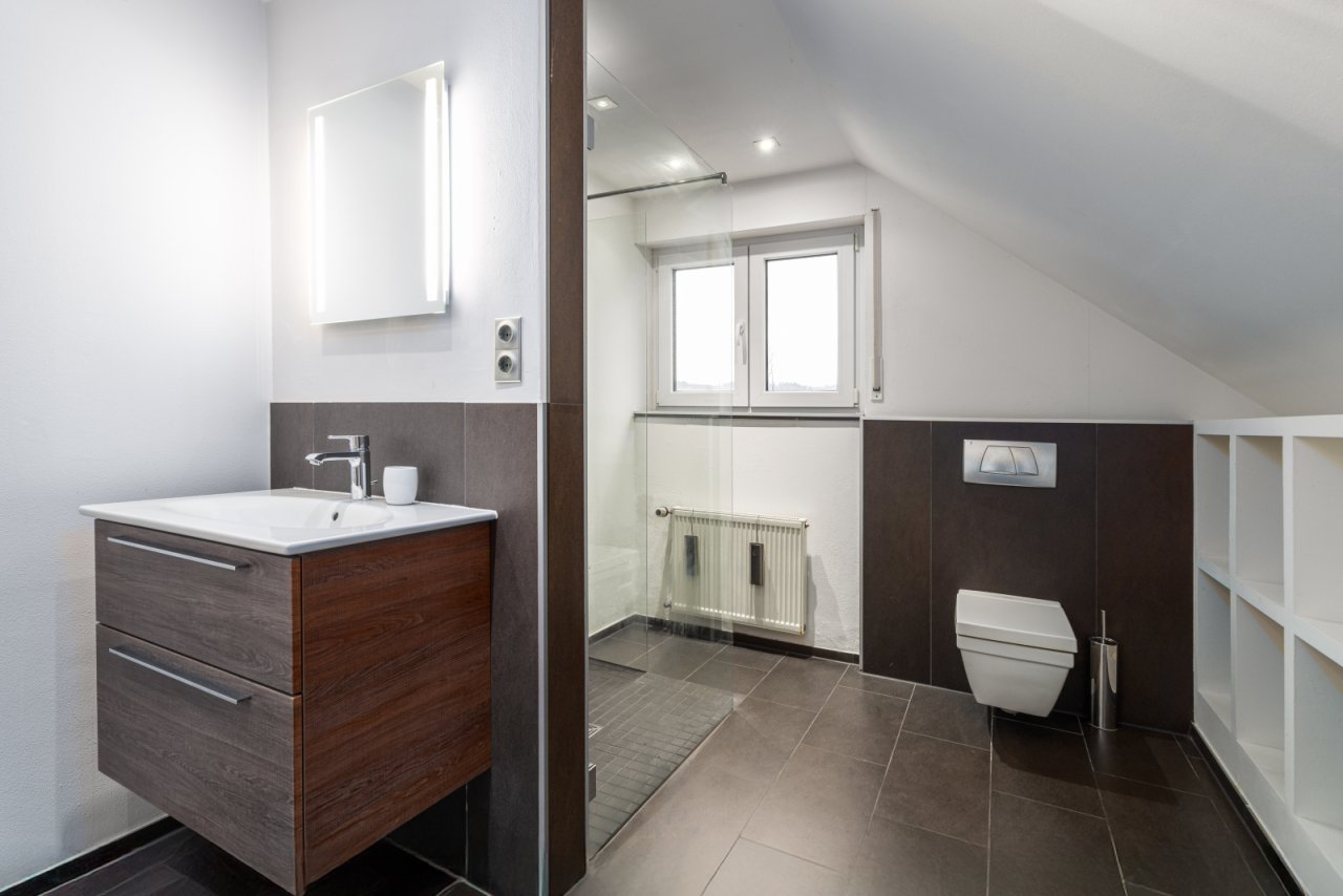 Modernes Dachgeschoss-Badezimmer mit cleverer Raumnutzung und Tageslicht-Fenster