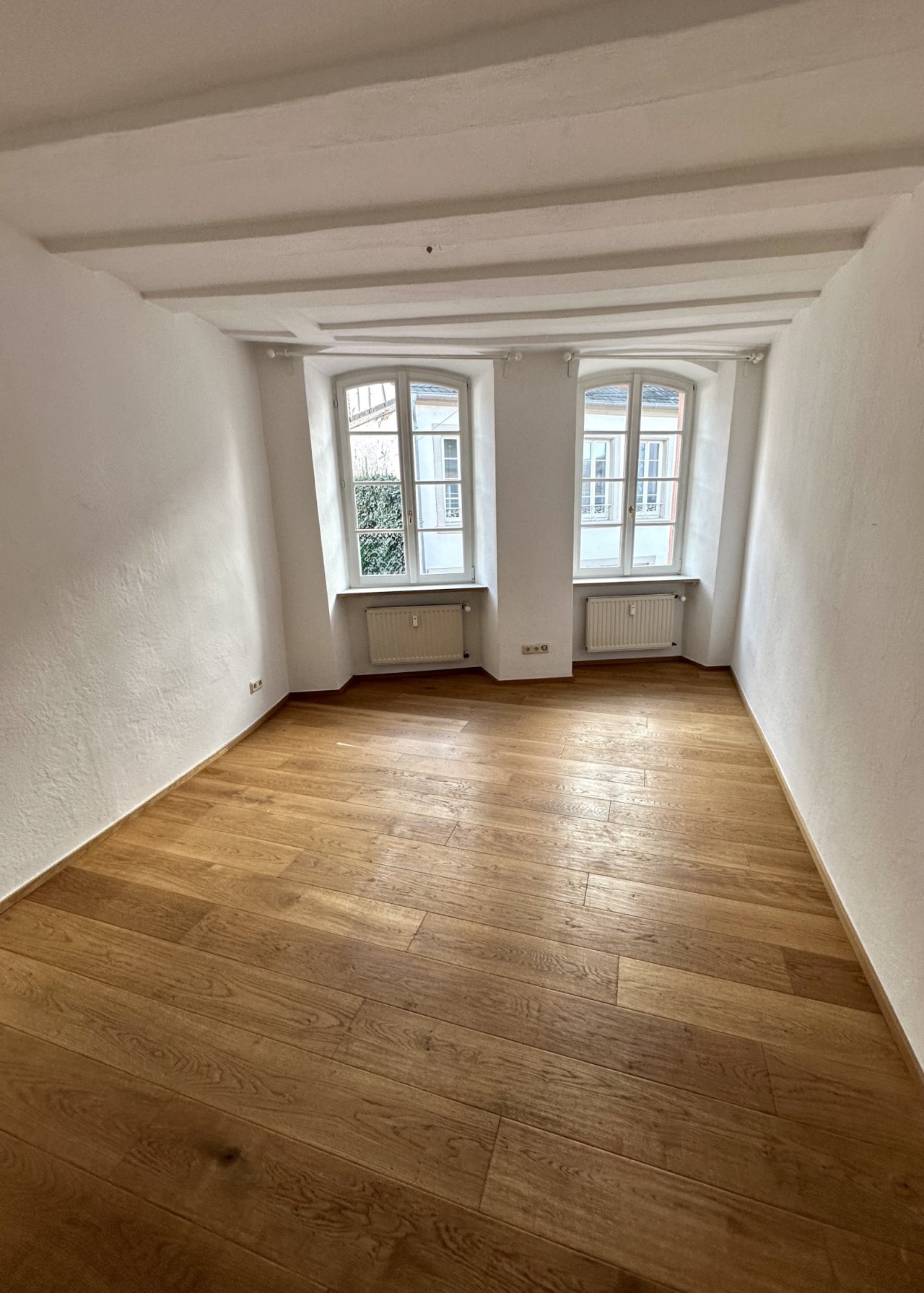 Hochwertige Eichenholzdielen und denkmalgeschützte Bogenfenster