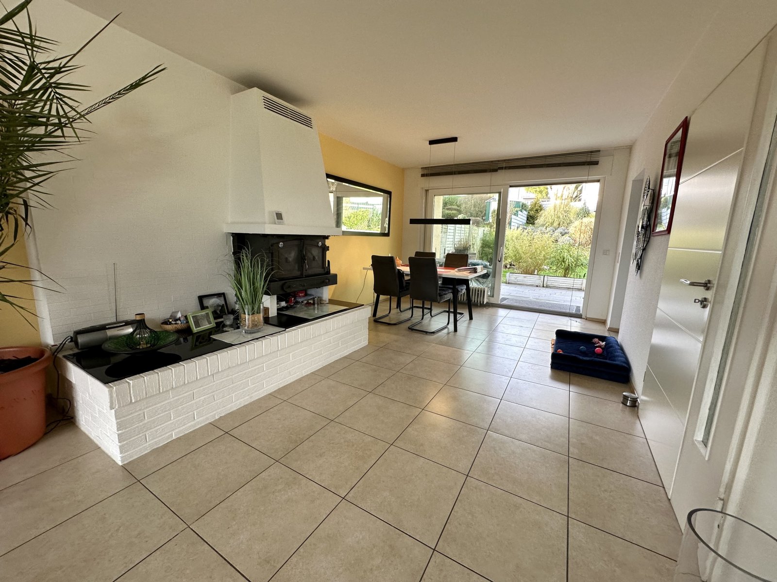 Lichtdurchfluteter Wohn-Essbereich mit elegantem Kamin und direktem Gartenzugang