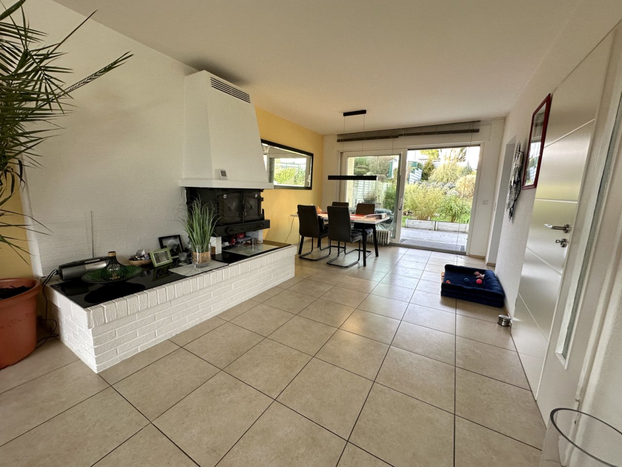 Lichtdurchfluteter Wohn-Essbereich mit elegantem Kamin und direktem Gartenzugang