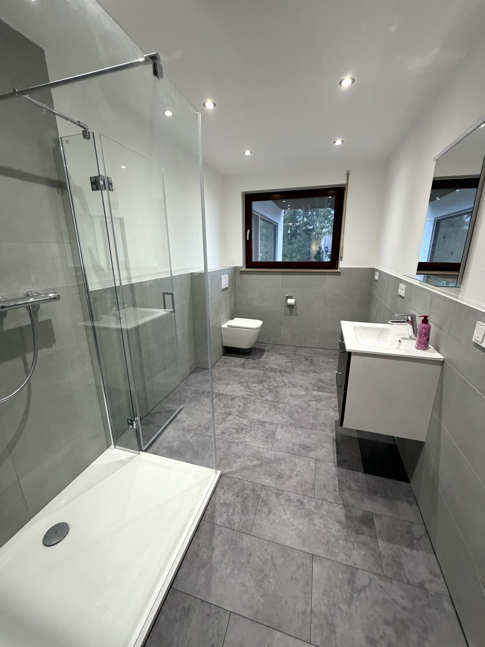 Modernes Badezimmer mit Komfort: Edle Glasdusche und natürliche Lichtführung