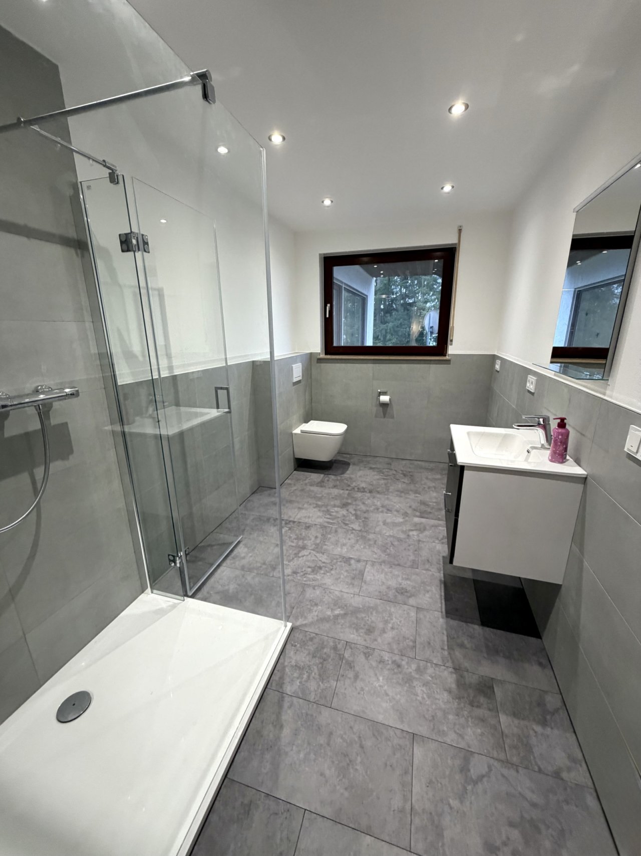 Modernes Badezimmer mit Komfort: Edle Glasdusche und natürliche Lichtführung