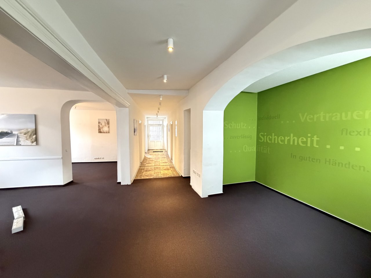 Lichtdurchfluteter Büro-Flurbereich mit eleganten Bögen und moderner Akzentwand