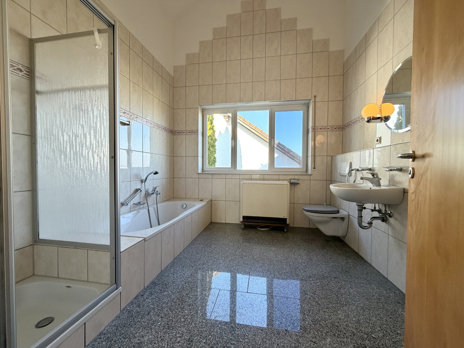 Modernes Badezimmer mit Wanne, Dusche und reichlich Tageslicht