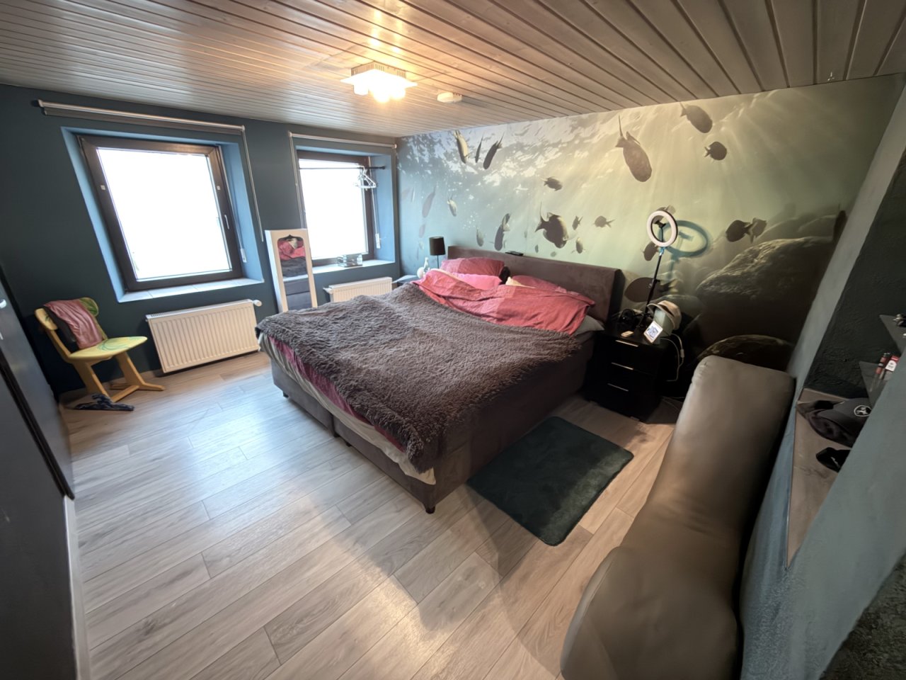 Helles Hauptschlafzimmer mit großflächigen Fenstern und Ankleidebereich