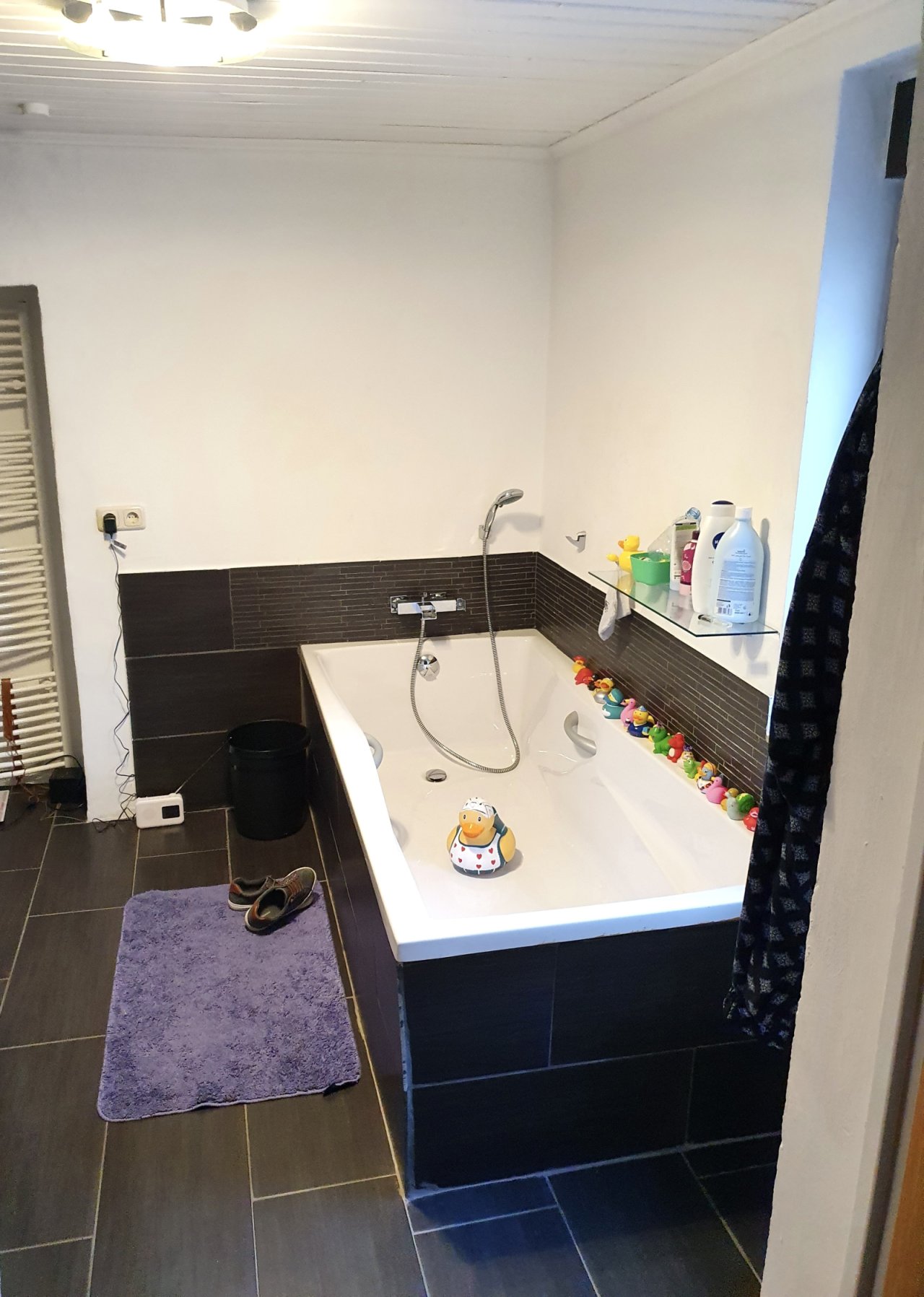 Modernes Badezimmer mit ebenerdiger Wanne und praktischer Ablage