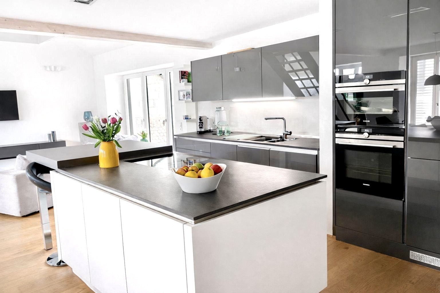 Moderne Designerküche mit zentraler Kochinsel und hochwertigen Einbaugeräten