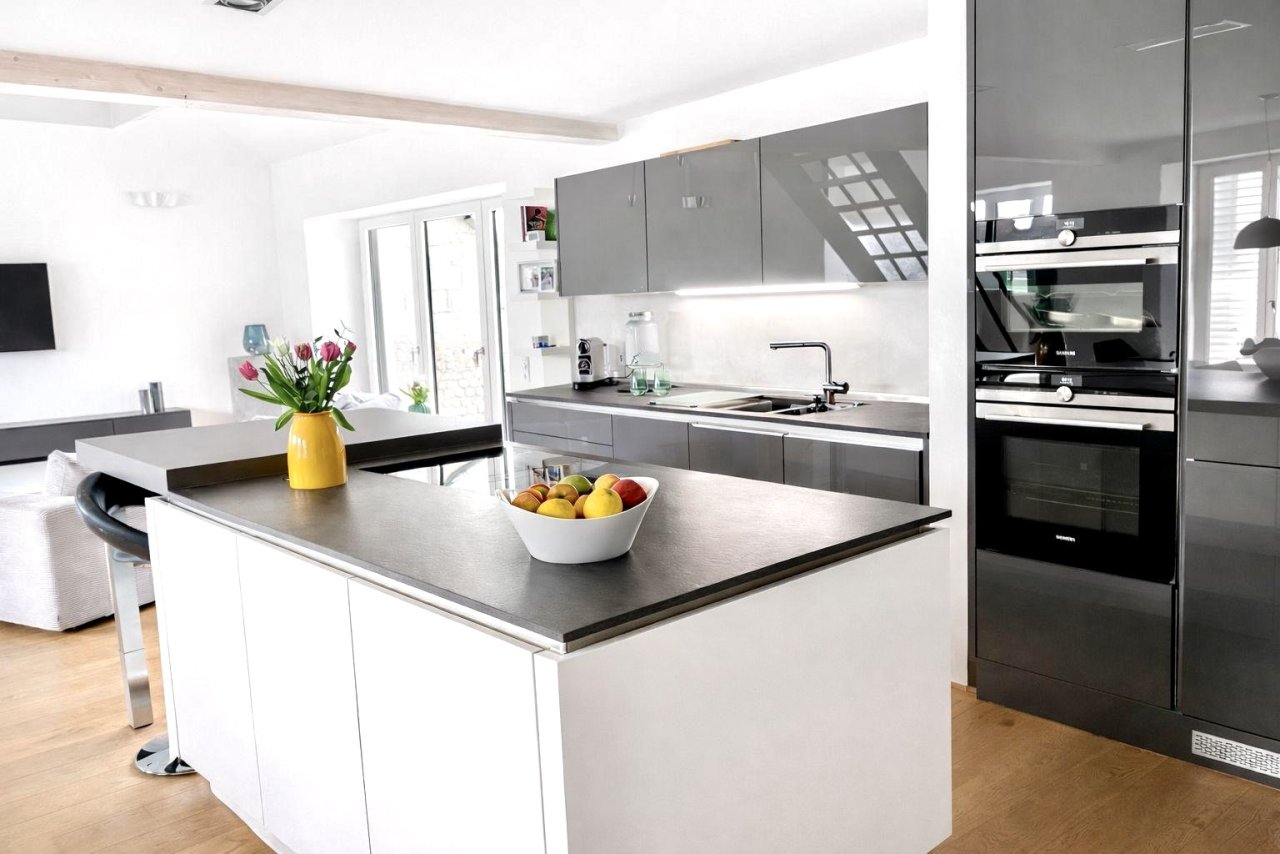 Moderne Designerküche mit zentraler Kochinsel und hochwertigen Einbaugeräten