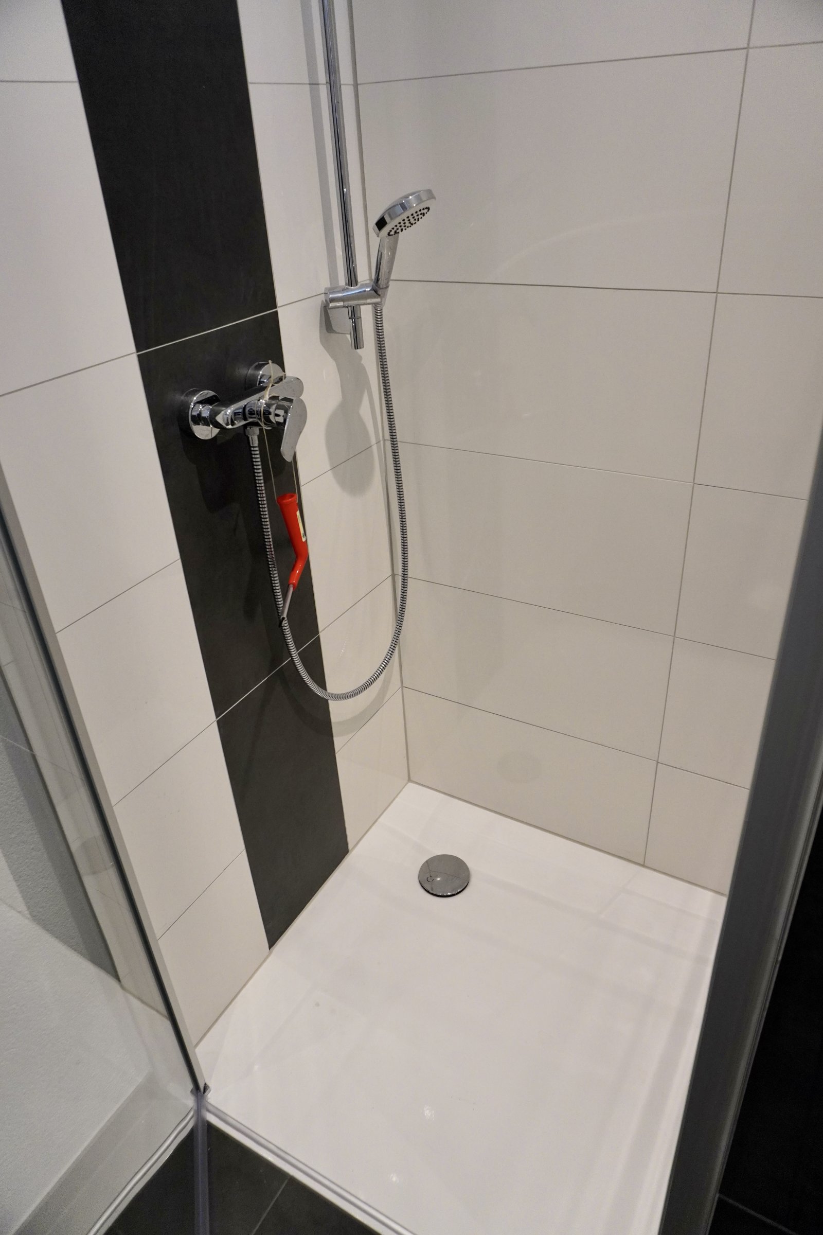 Modernes Duschbad mit ebenerdiger Dusche und chromglänzender Armatur