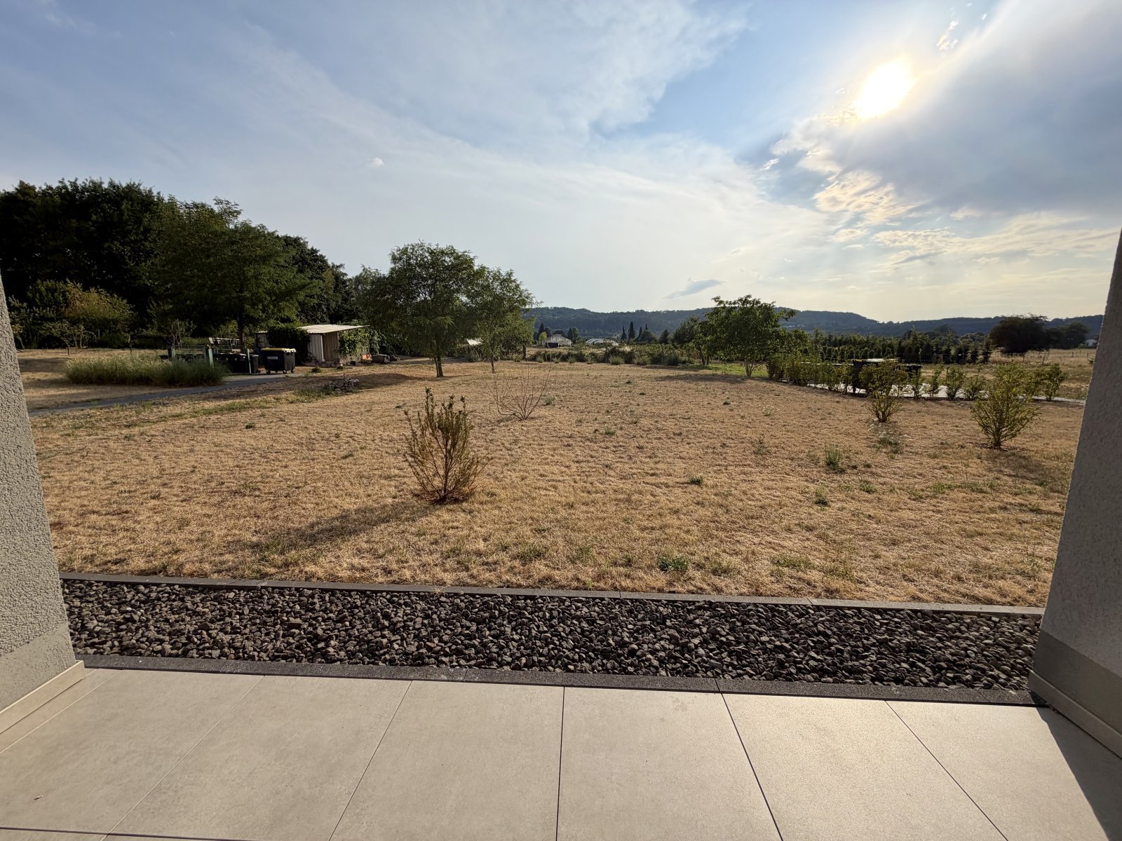 Terrassenzugang mit unverbaubarem Landblick und modernem Kiesstreifen