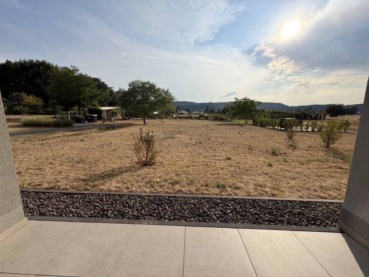 Terrassenzugang mit unverbaubarem Landblick und modernem Kiesstreifen