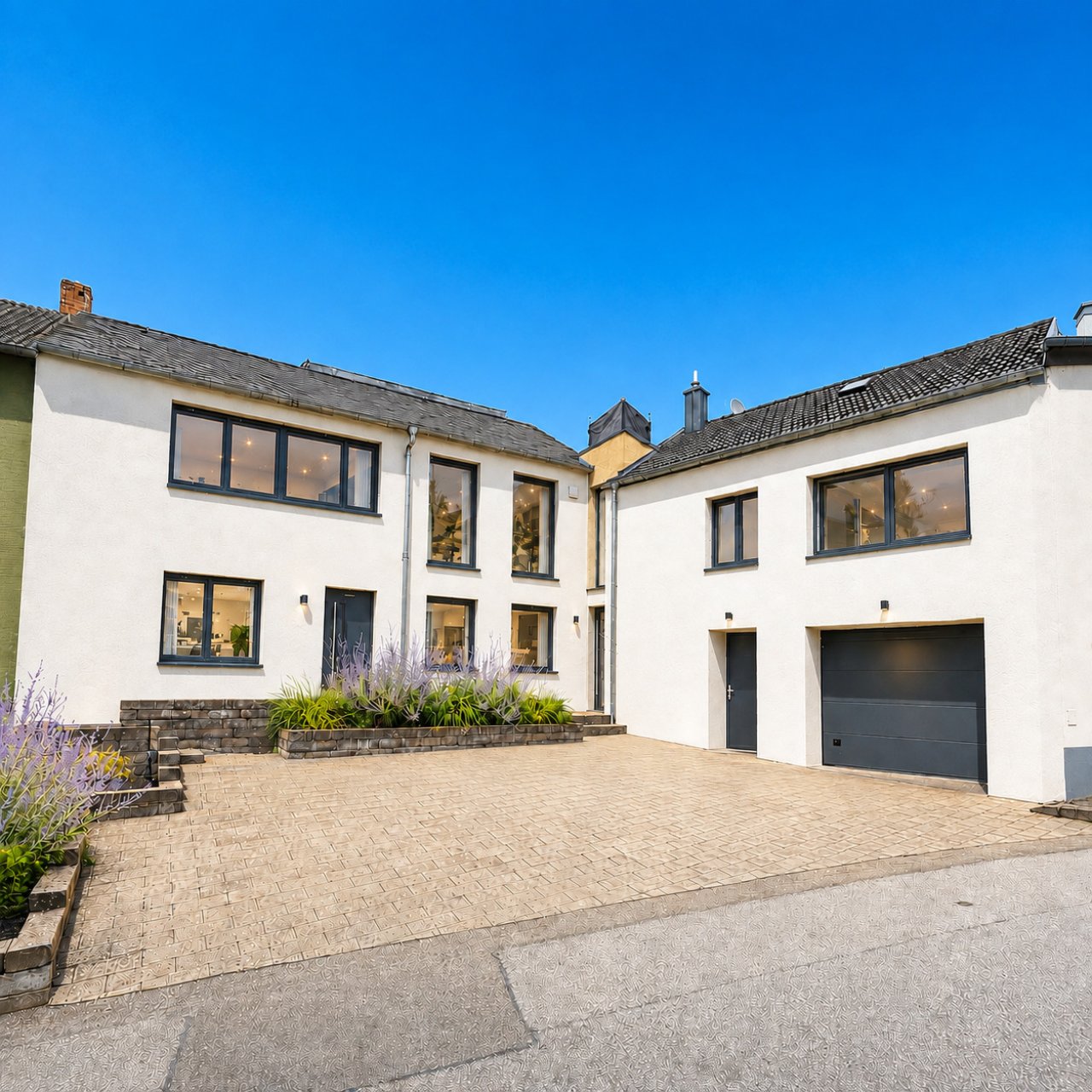 Moderne Fassade mit großflächigen Fenstern und integrierter Garage Moderne Fassade mit großflächigen Fenstern und integrierter Garage