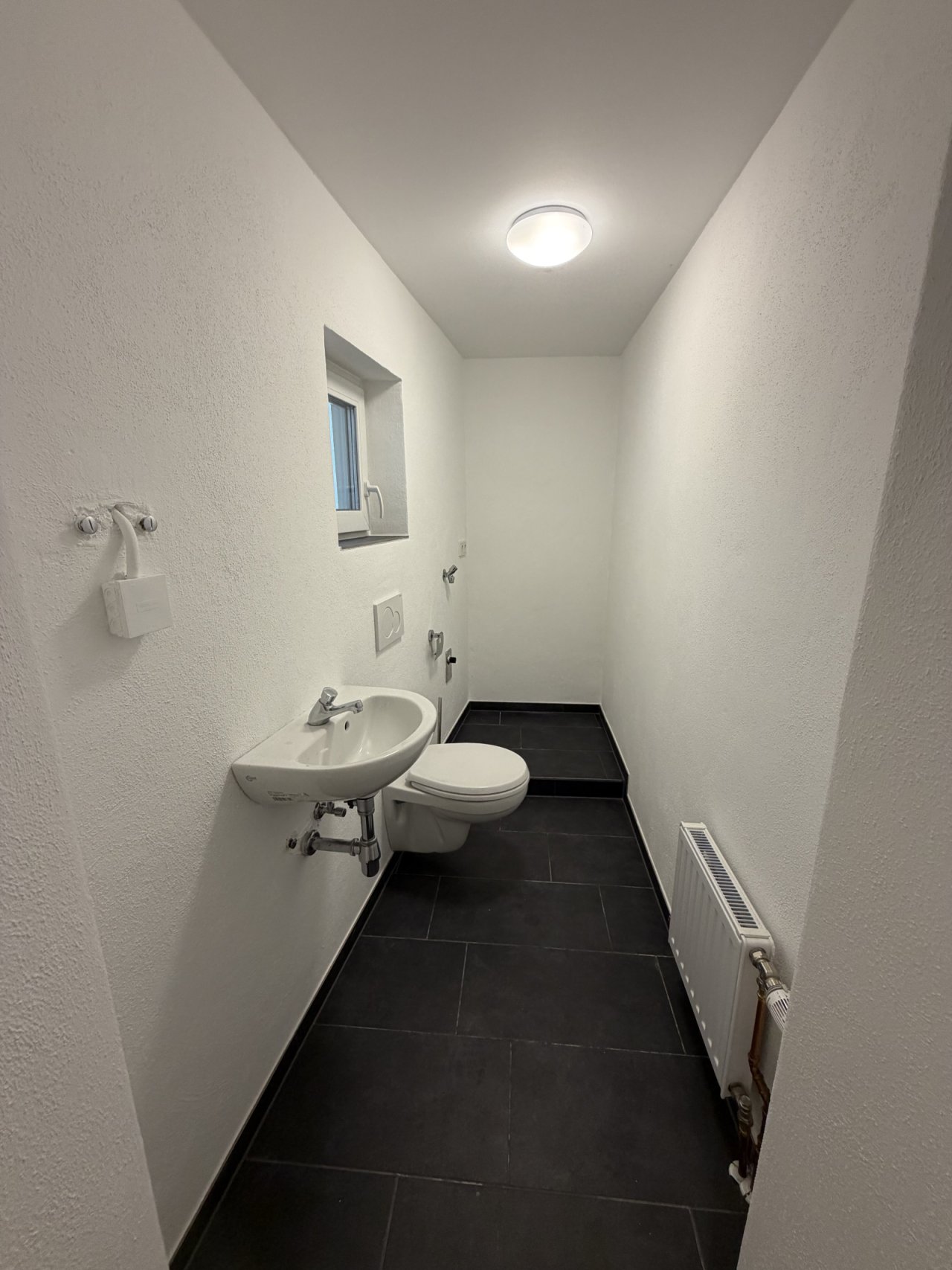 Funktionales Gäste-WC mit kompaktem Grundriss und modernem Fliesenbelag